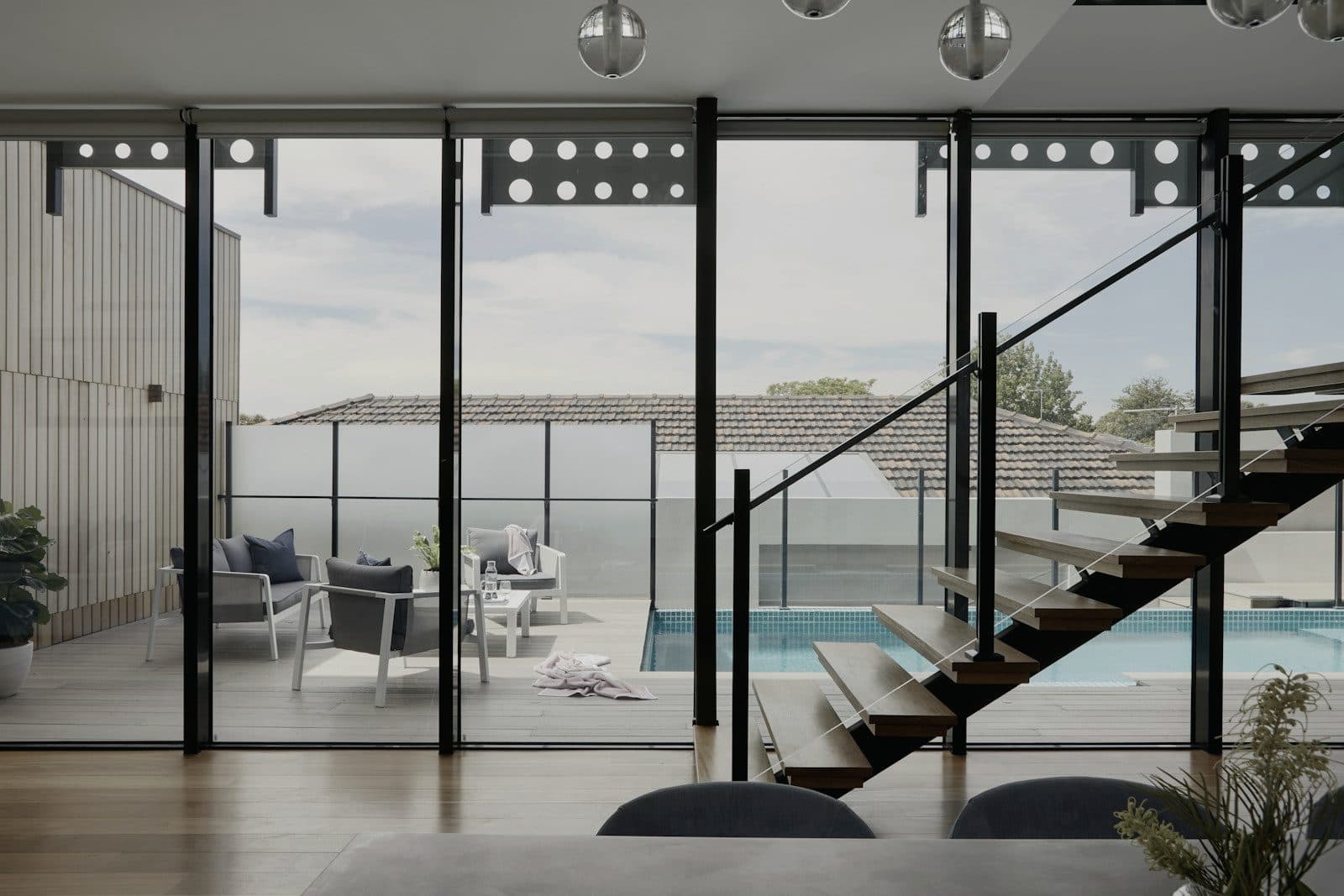 Salón acristalado abierto a una piscina exterior